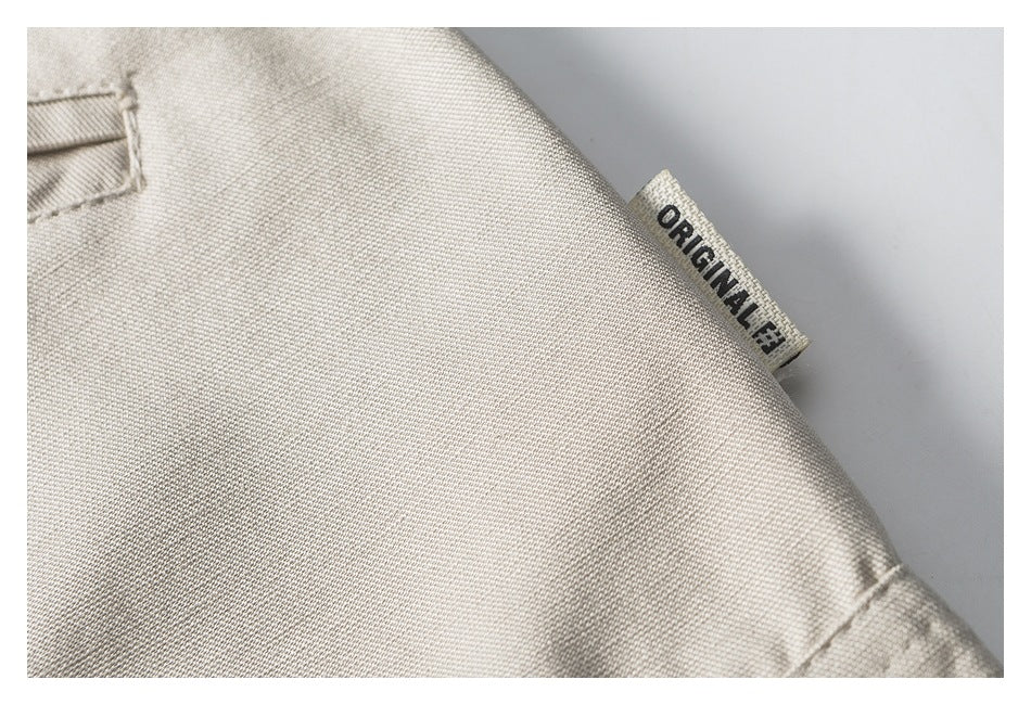 Close-up of light beige garment fabric with a small sewn label reading “ORIGINAL.”