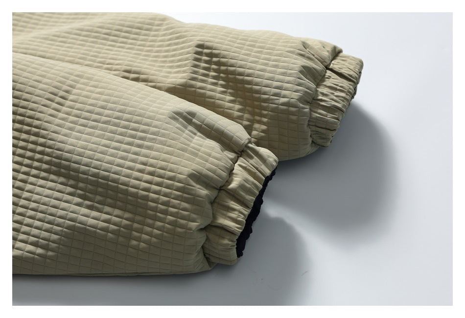 Close-up of beige quilted jacket sleeves with gathered elastic cuffs.