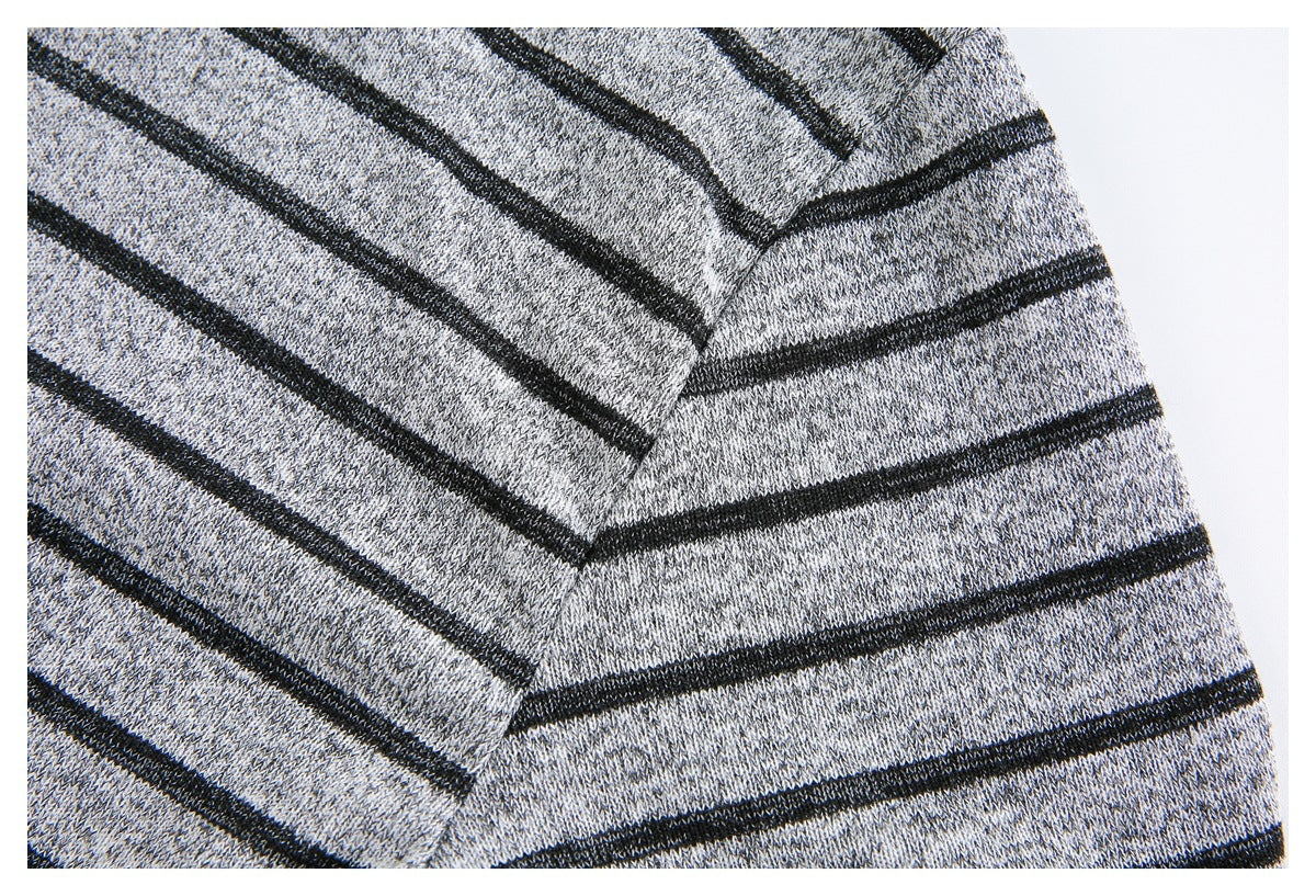 Close-up of a seam joining two sections of gray knit fabric with black stripes.