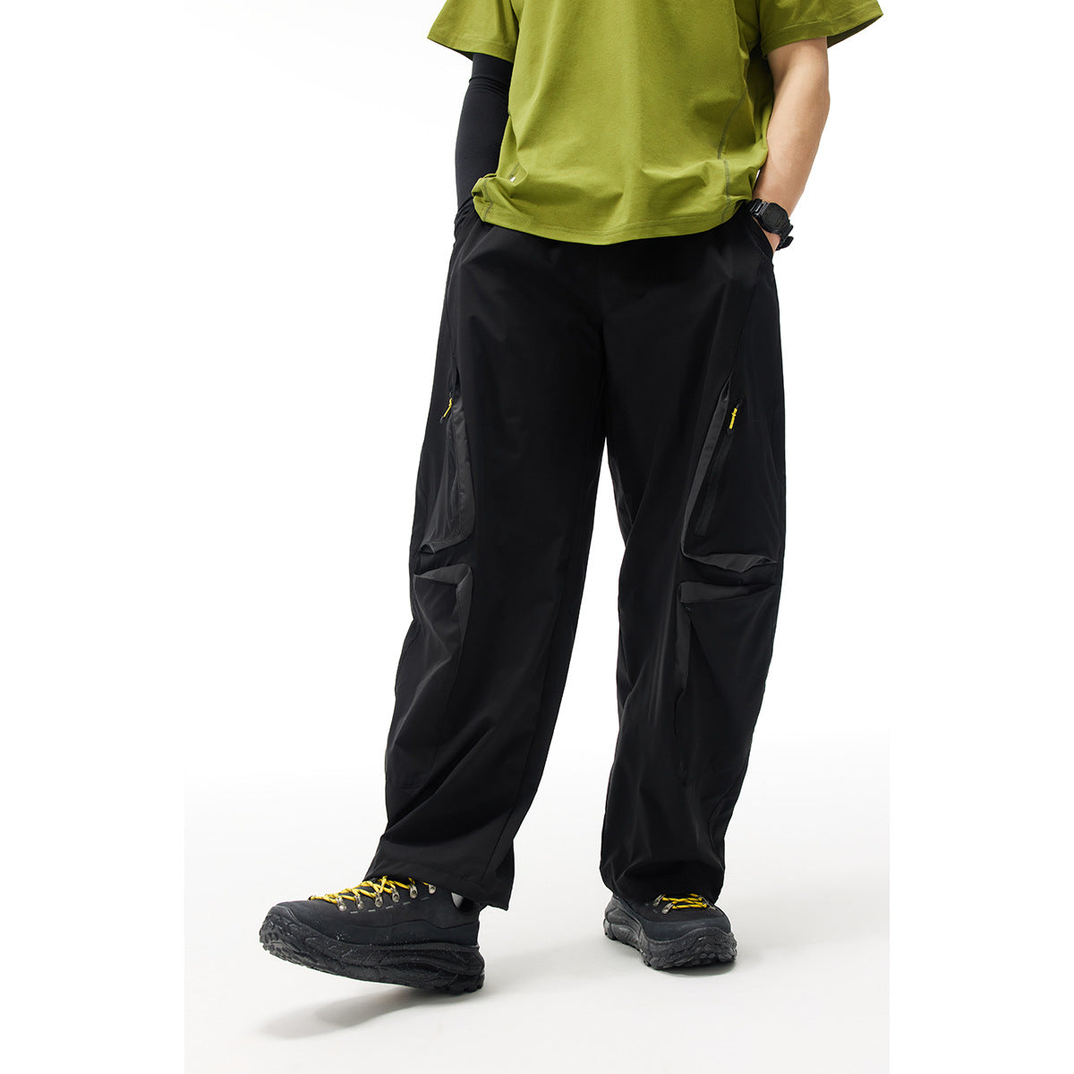 Model wearing black wide-leg cargo pants with zip pockets and large flap pockets, shown from the front.