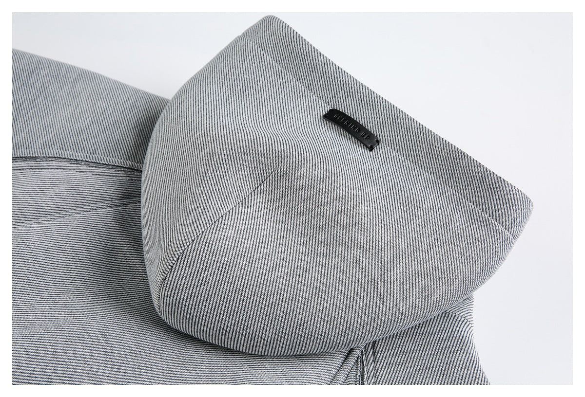 Close-up of a black-and-white striped garment panel with curved seams and a small black label.