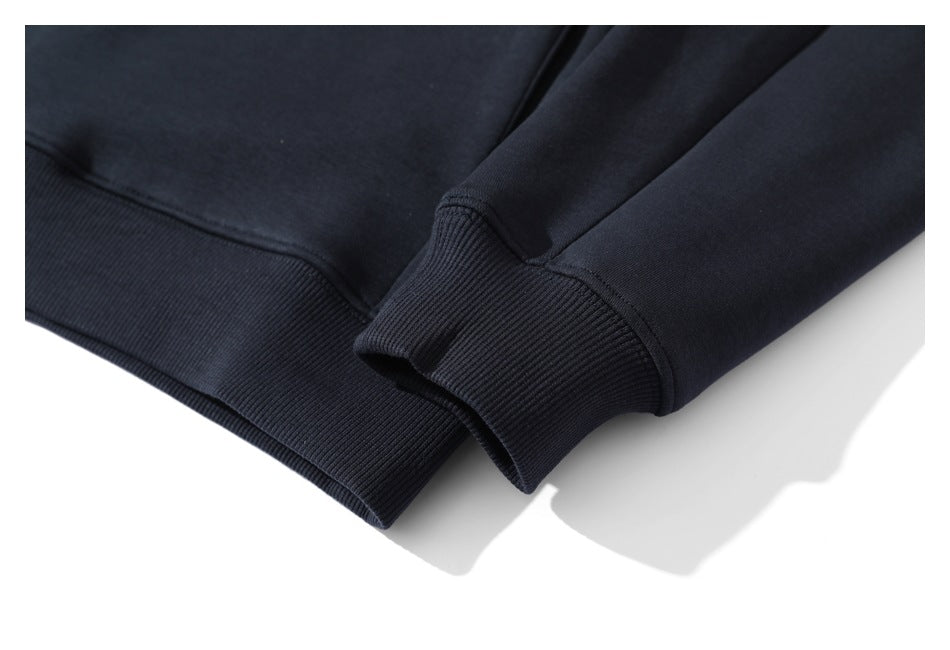 Close-up of a dark navy sleeve cuff and garment hem, both finished with ribbed bands.