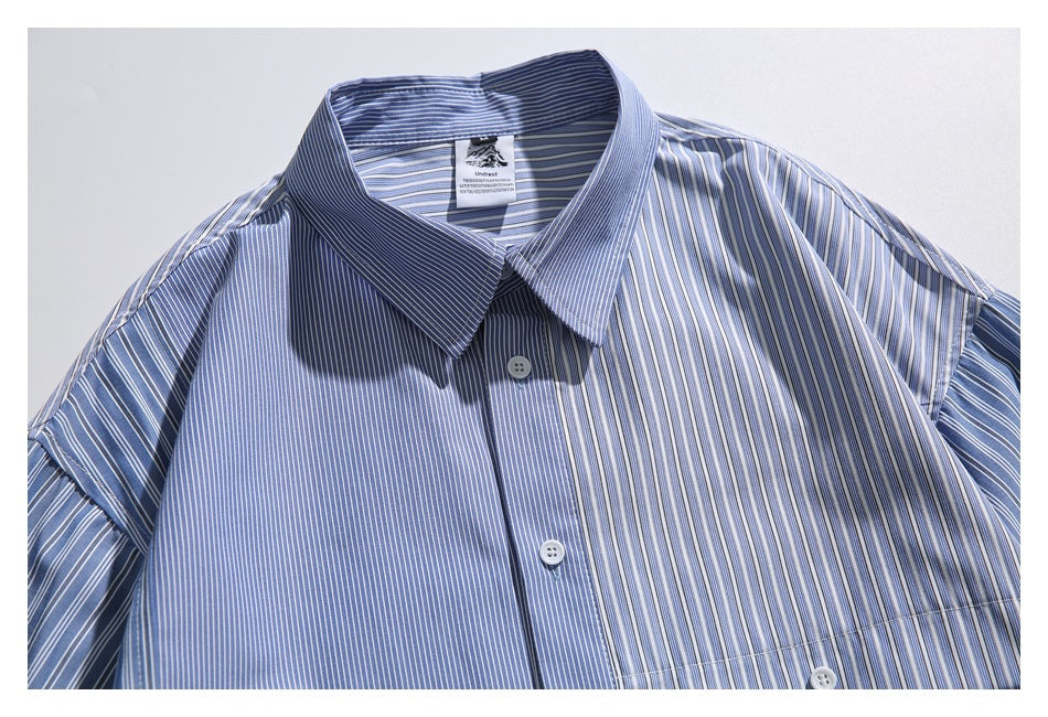 Close view of a blue-and-white striped button-up shirt with a pointed collar and stripes running in different directions.