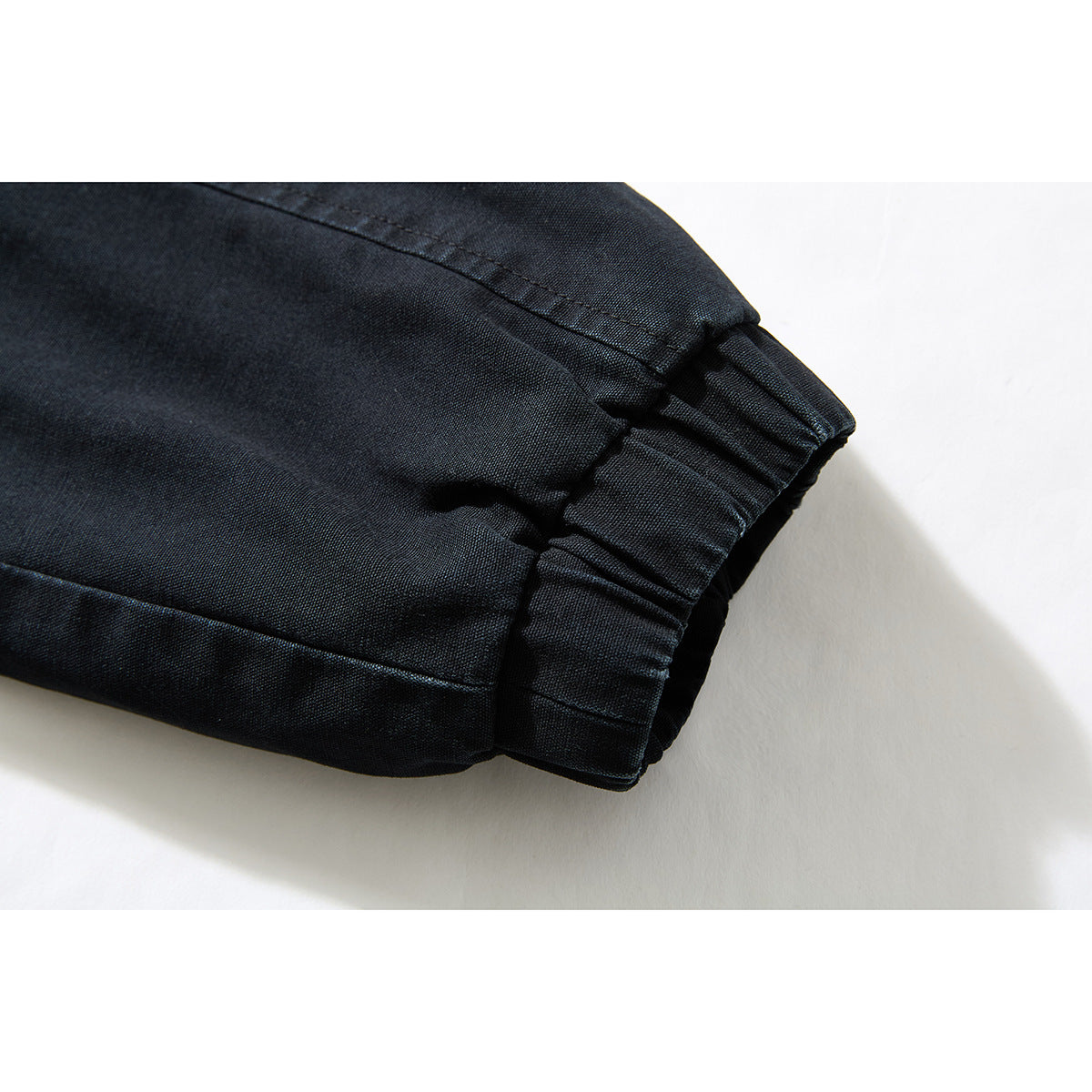 Close-up of a black jacket sleeve ending in a gathered cuff.