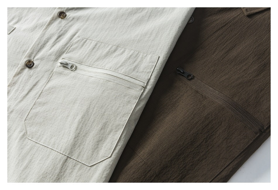 Close-up of off-white and dark brown shirts showing button fronts and zippered chest pockets.