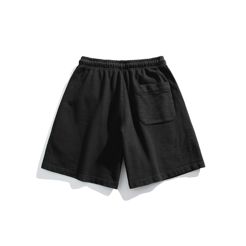 Black shorts shown from the back, with an elastic waistband and a single patch pocket.