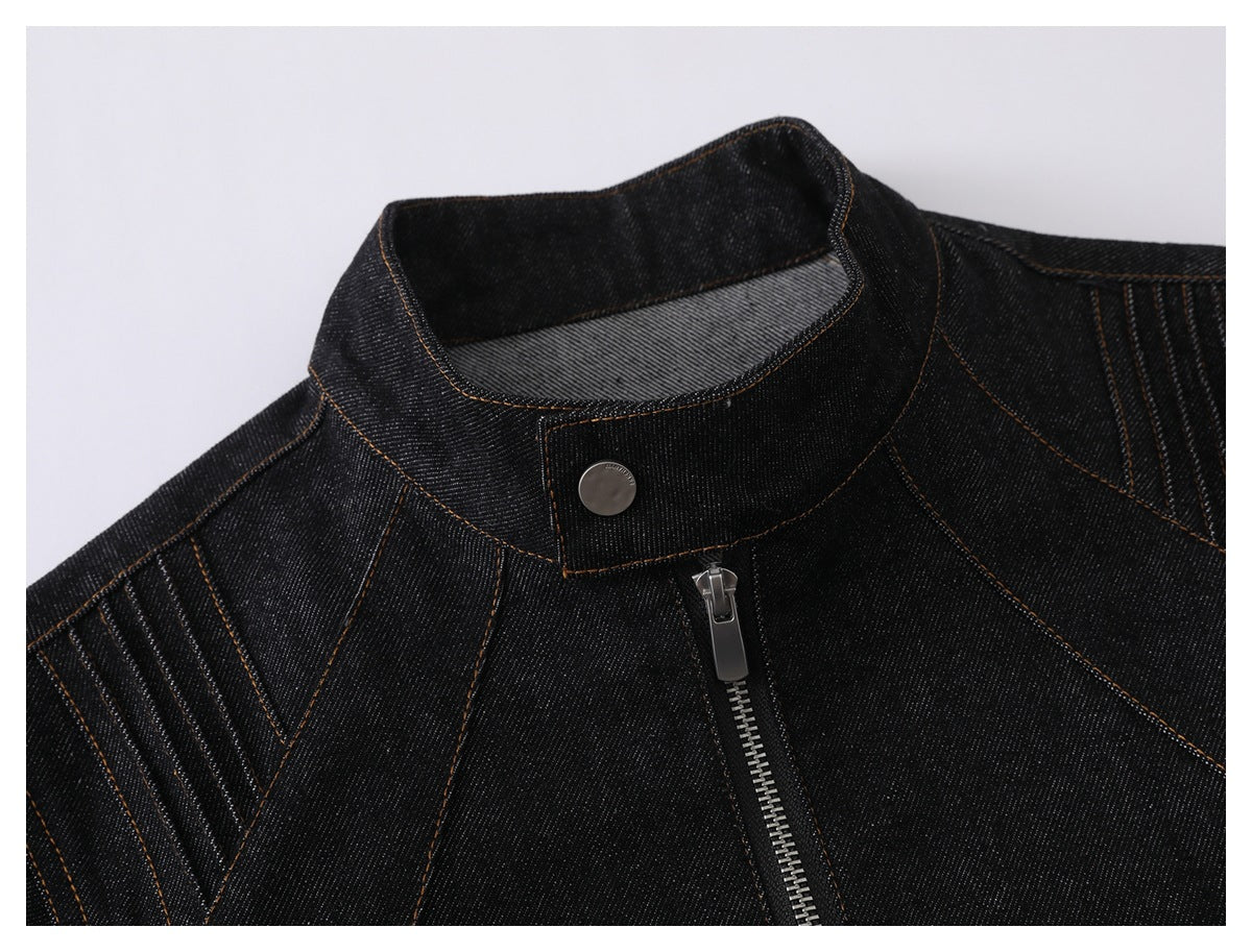 Close-up of a black denim jacket’s stand collar, silver snap, zipper, and contrast stitching.