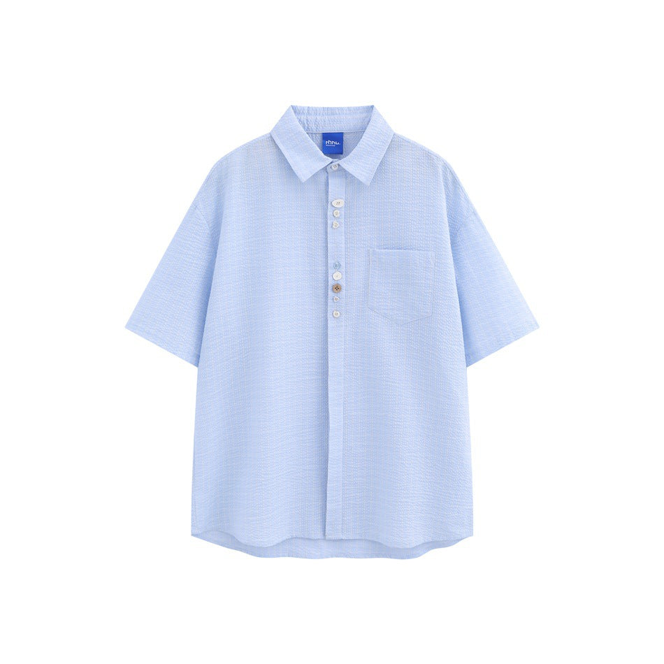 Light blue short-sleeve textured shirt with mismatched buttons, chest pocket and pointed collar, flat front view