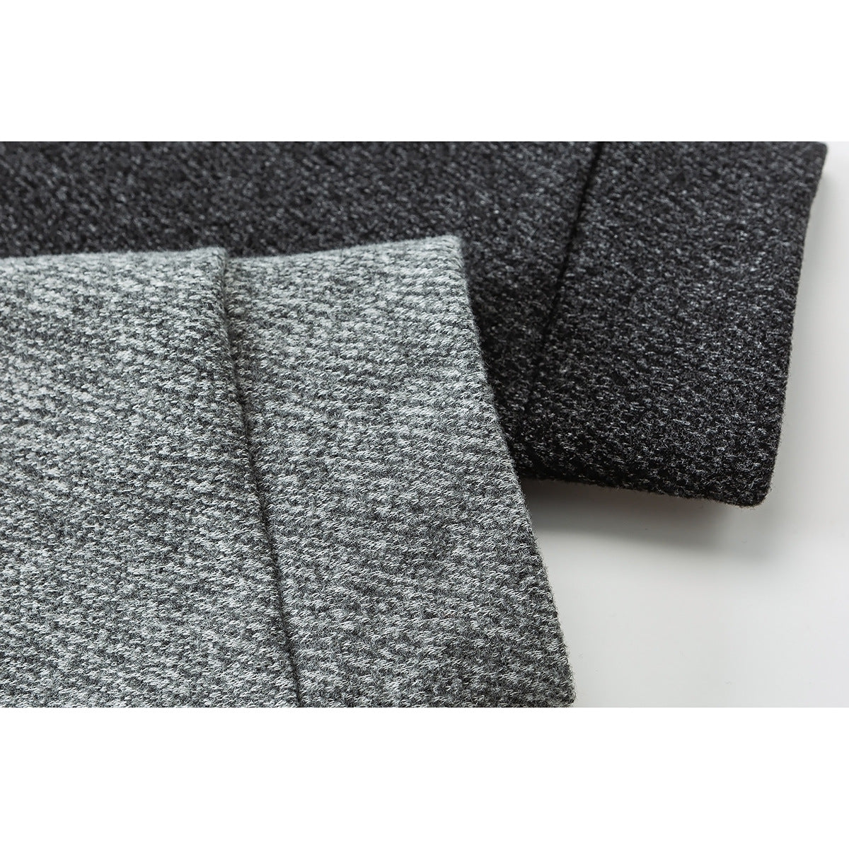 Close-up of light gray and charcoal textured knit sleeves with folded cuffs.