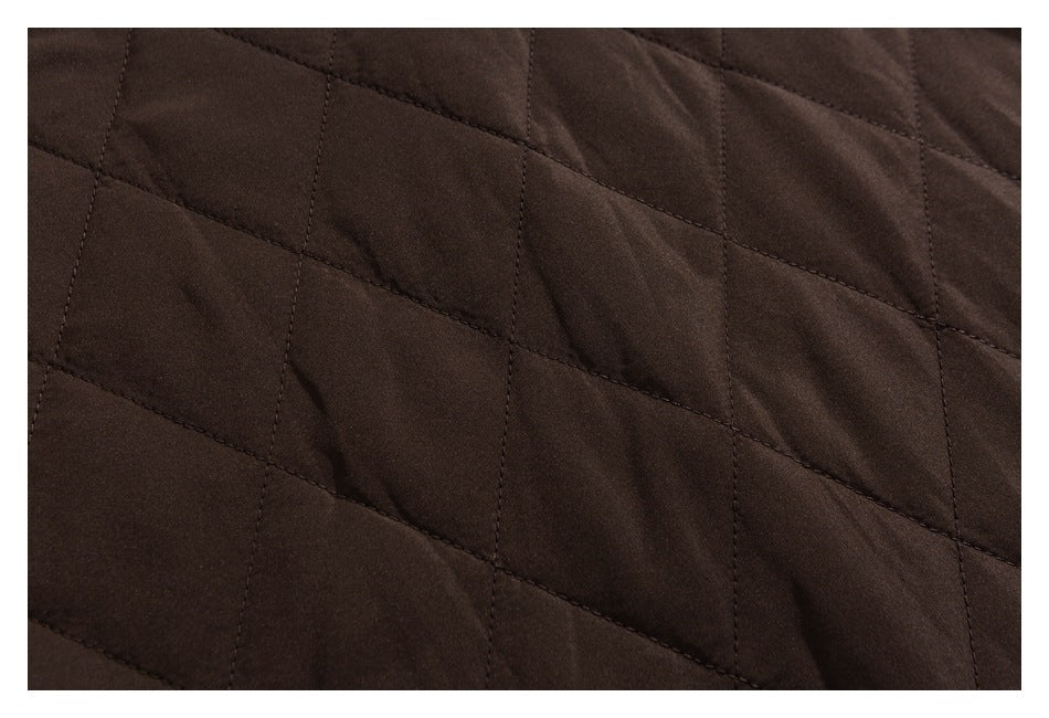 Close-up of dark brown quilted fabric with diagonal stitching forming large diamond shapes.