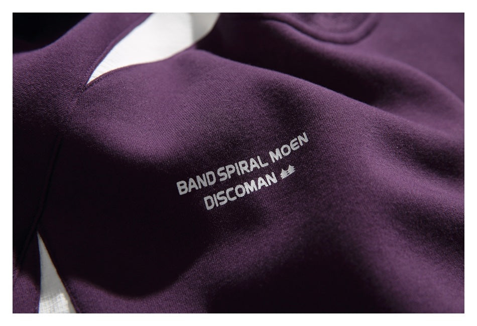 Close-up of the plum sweatshirt's white English chest print reading “BAND SPIRAL MOEN DISCOMAN.”