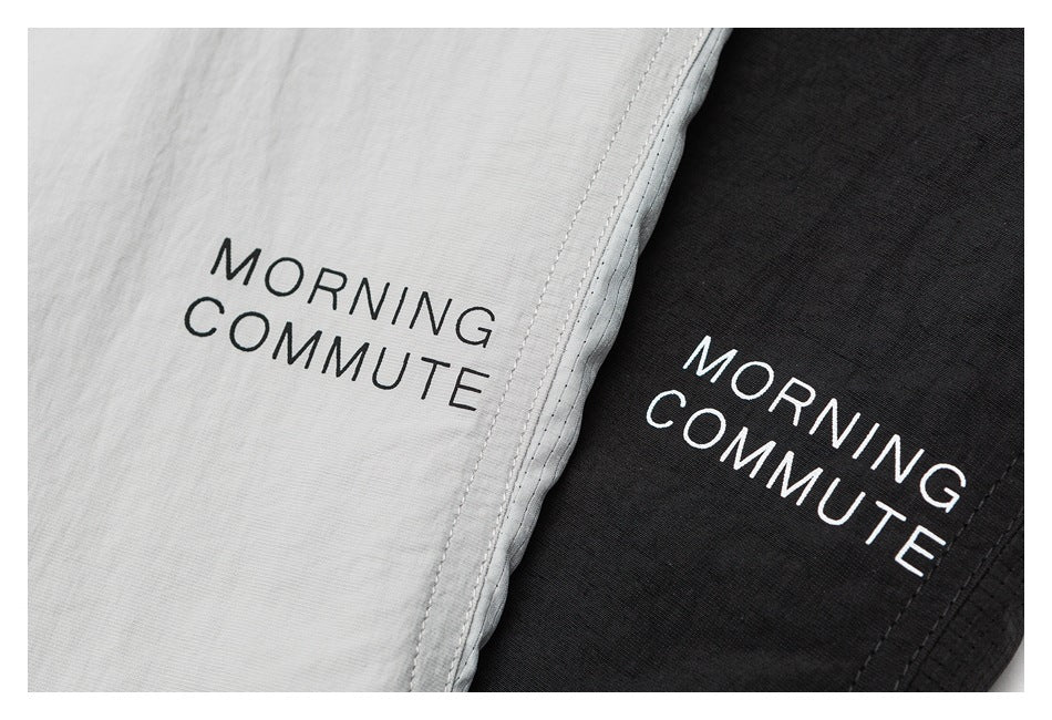 Close-up of light gray and black shirt fabric, both printed with “MORNING COMMUTE.”