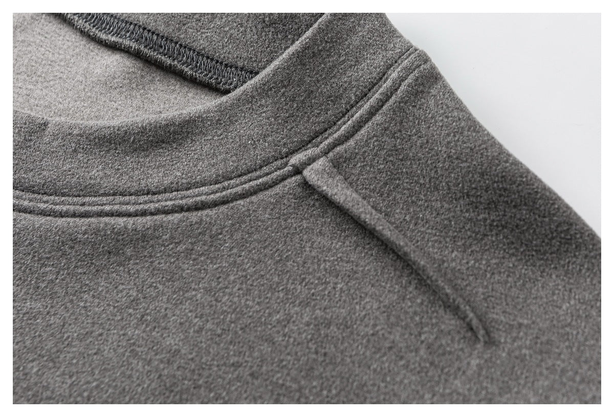 Close-up of a gray garment's rounded neckline and stitched shoulder seam.