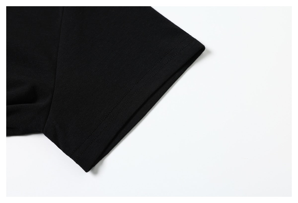 Close-up of the black T-shirt's short sleeve and stitched hem against a white background.