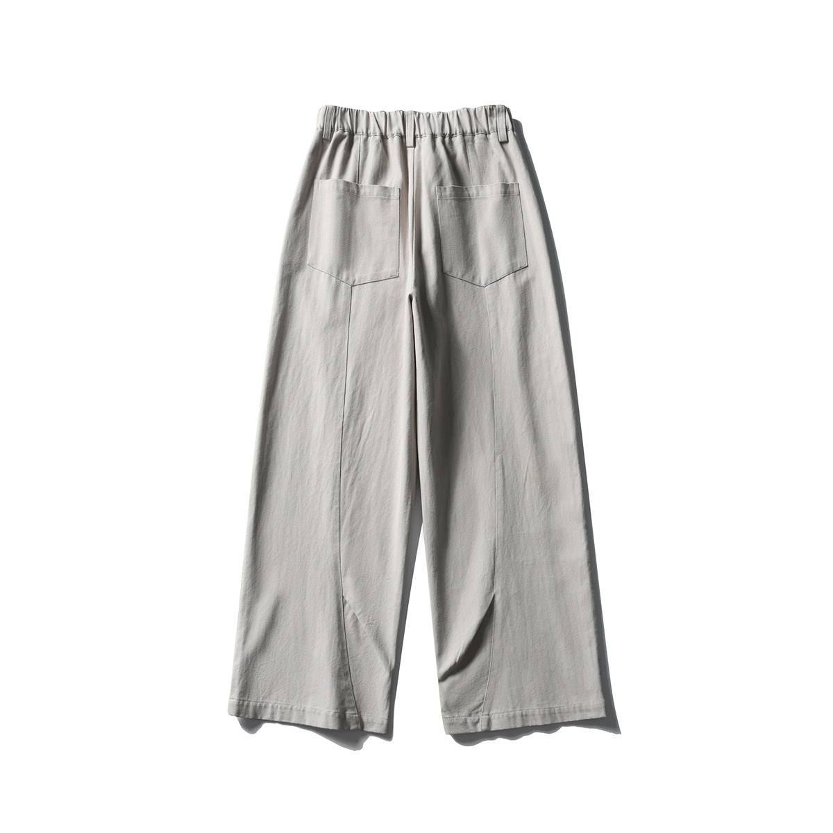 Back view of light gray wide-leg trousers with an elasticated waistband and two rear patch pockets.