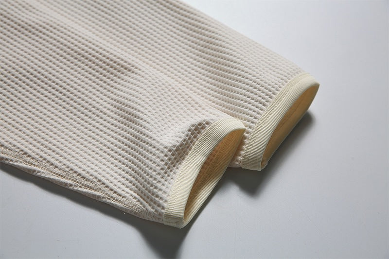 Close-up of the cream waffle-knit sleeve ends with ribbed cuffs.