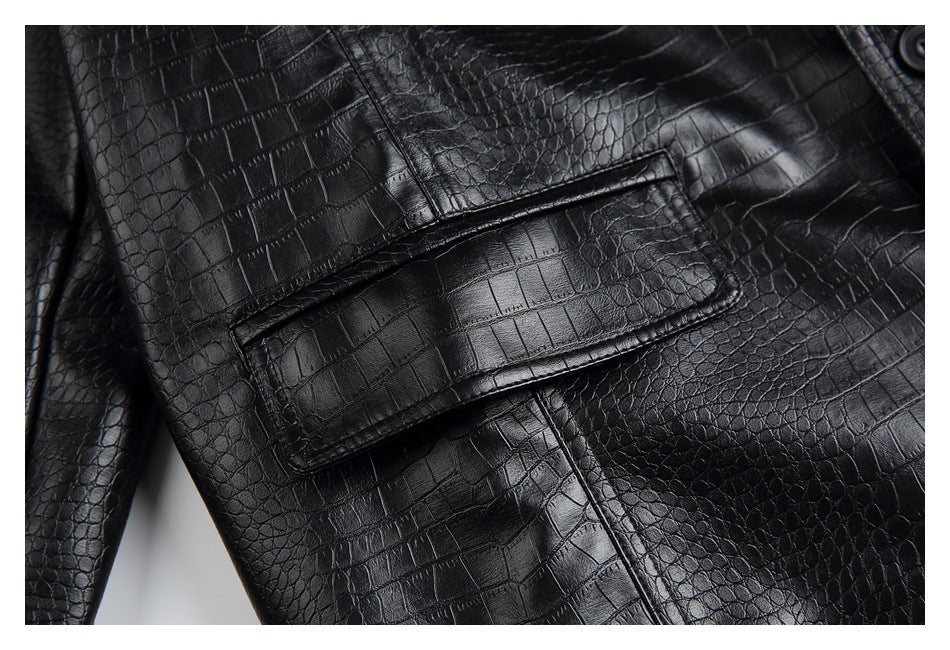 Close-up of a flap pocket on the black jacket, showing glossy crocodile-textured panels and stitching.