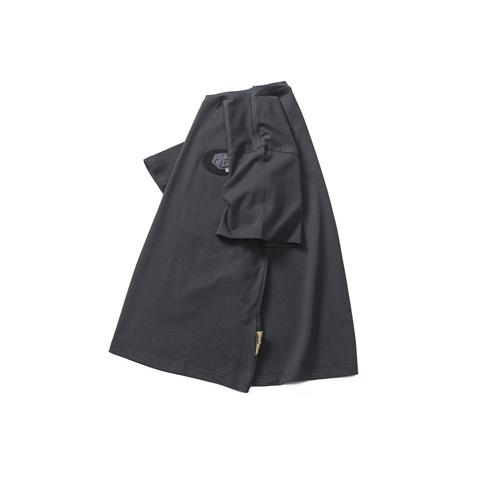 Dark charcoal short-sleeve crew-neck T-shirt arranged flat, showing a small raised chest emblem.