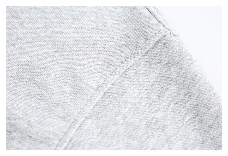 Close-up of light gray shirt fabric and a diagonal stitched seam.