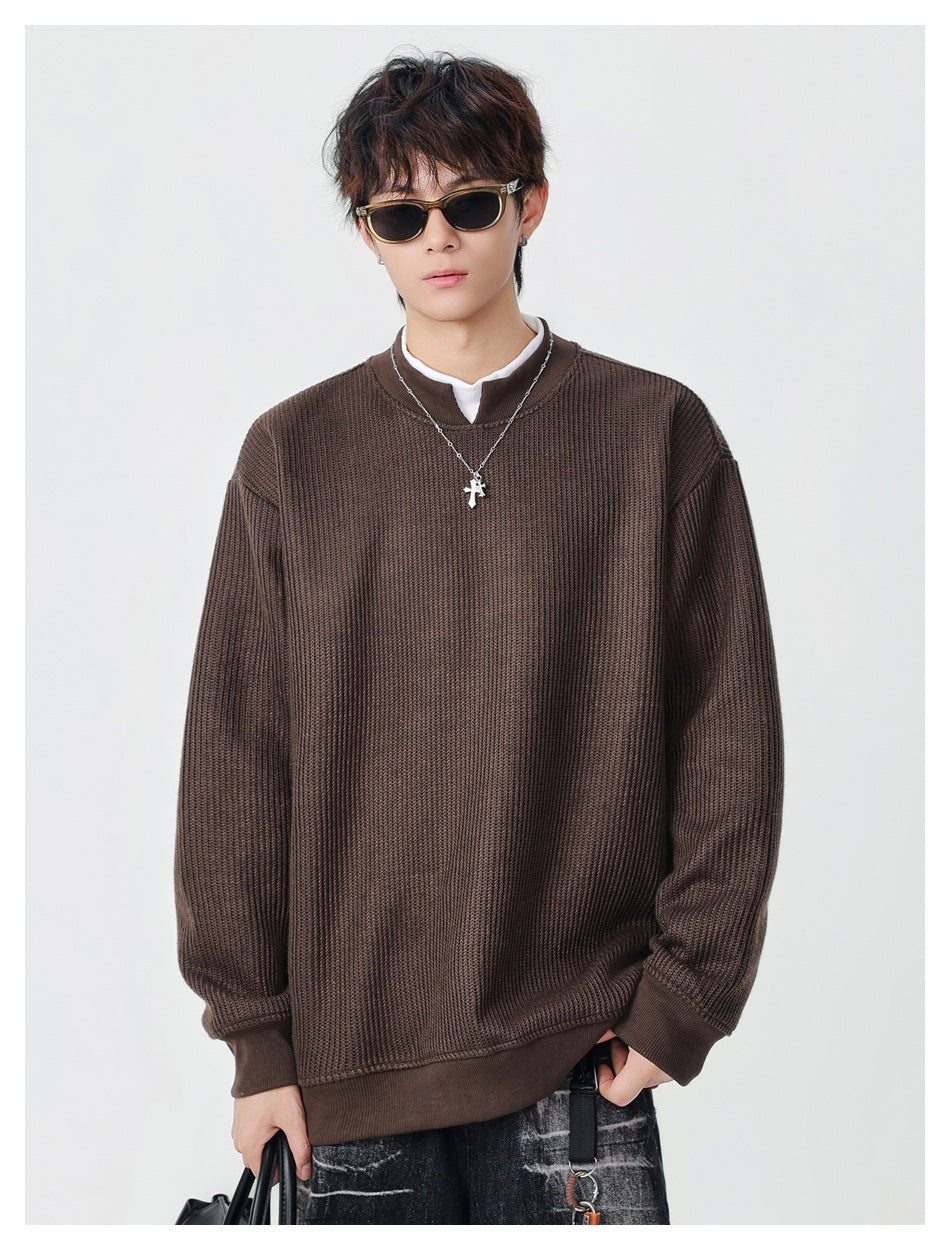 Model wearing brown relaxed ribbed pullover with white inner collar and cross necklace, front view