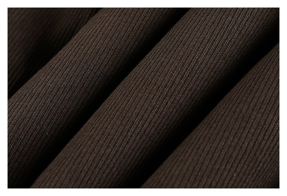 Extreme close-up of the dark brown garment's fine vertical ribbed texture.