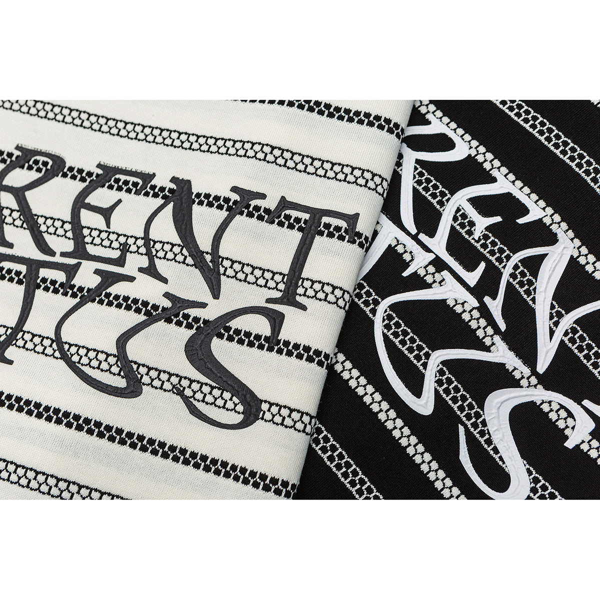 Close-up of ivory and black striped T-shirts with large contrasting lettering across the fronts.