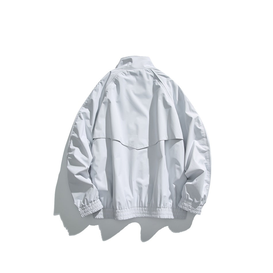 Back view of a light gray jacket with a back vent, gathered cuffs, and an elastic hem.