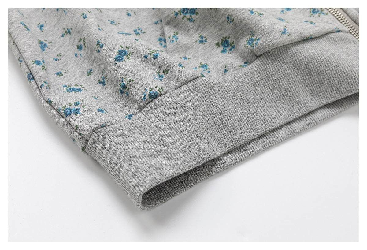 Close-up of the wide ribbed gray hem on a blue-floral hoodie.