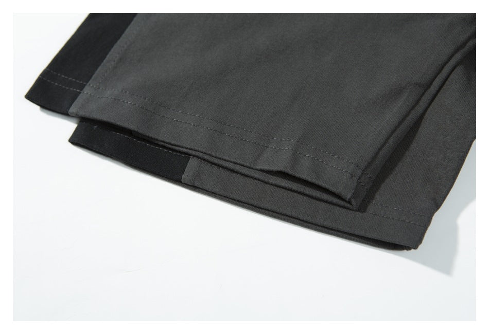 Close-up of the shirt hem with charcoal and black layers and parallel rows of stitching.