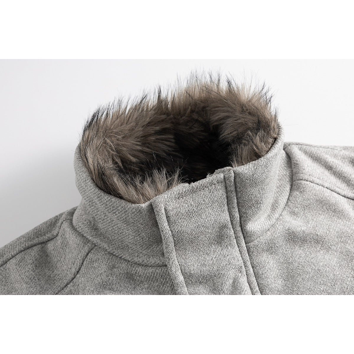 Close-up of a gray jacket's high collar with dark faux-fur trim and a covered front placket.