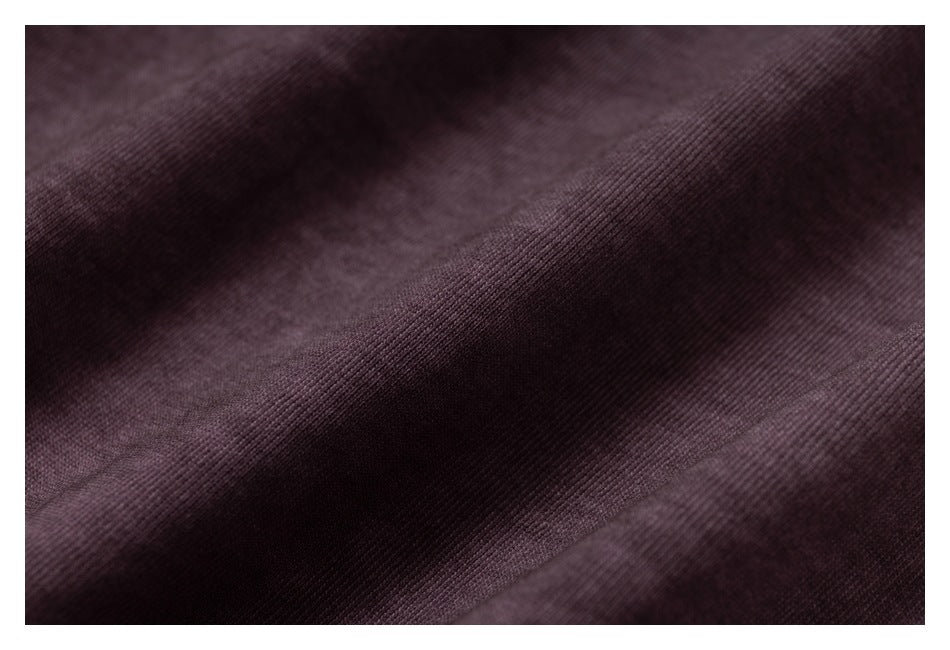Macro view of the fine knit texture and folds of dark plum fabric.