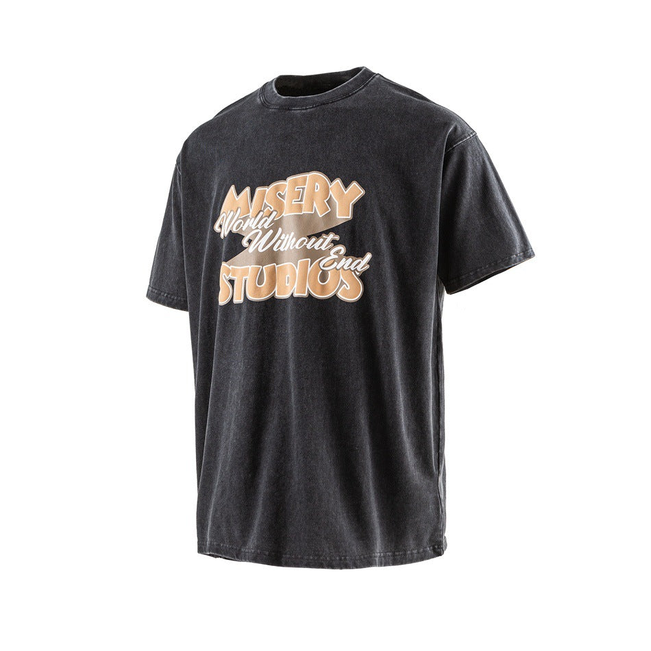 Front view of a washed black T-shirt with tan and white lettering across the chest.