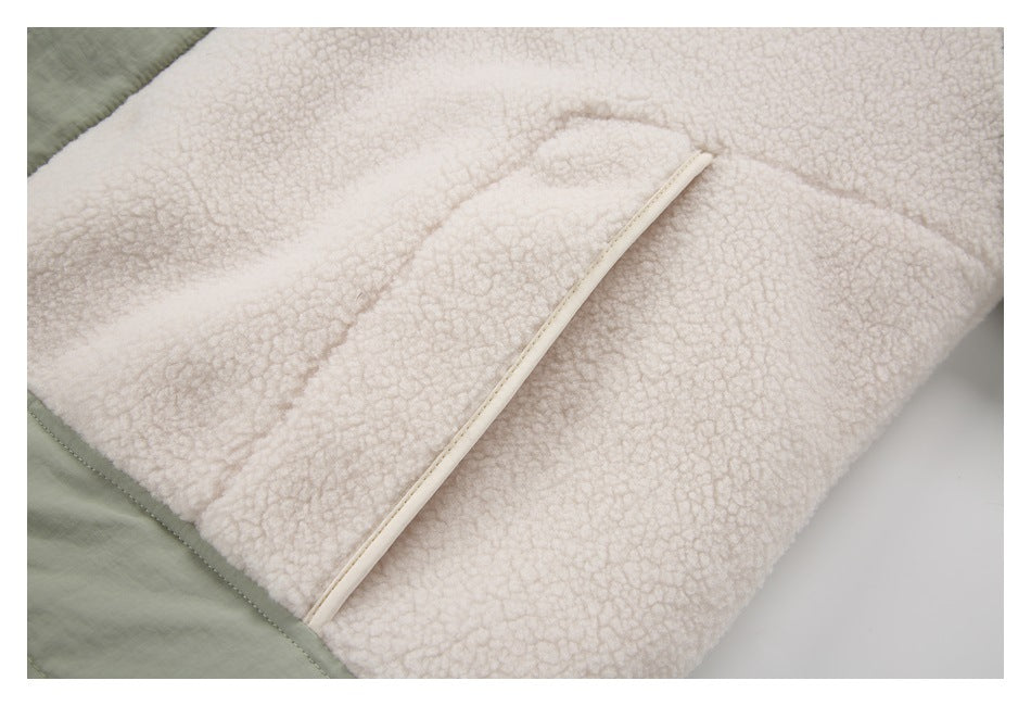 Close-up of a cream fleece jacket section with a narrow light-colored trim and sage-green edge.