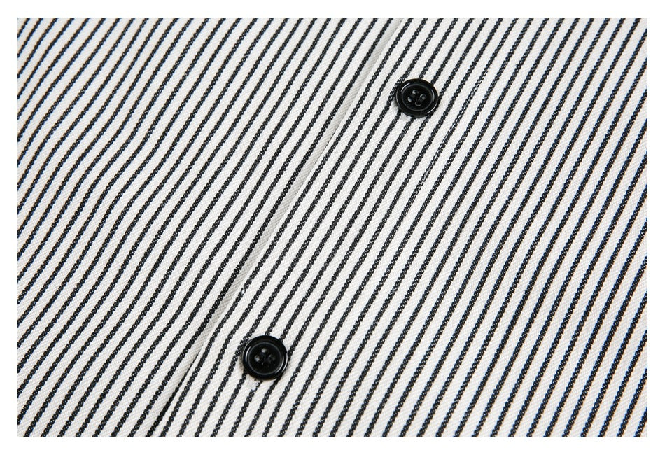 Close-up of two black buttons on black-and-white striped fabric.