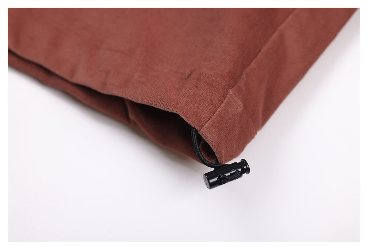 Close-up of the rust-brown shirt hem with a black drawcord toggle.