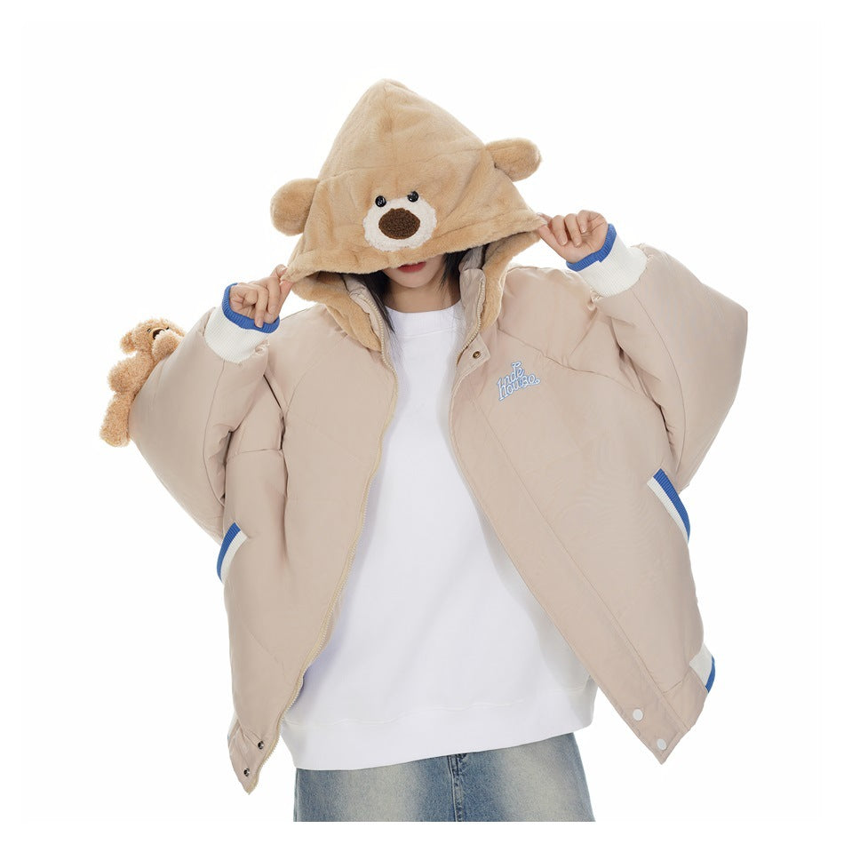 Model showing the open beige jacket, plush bear-face hood, blue-and-white cuffs, and white top.