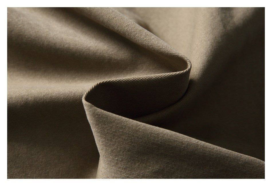 Close-up of khaki fabric folded to show its fine diagonal weave.