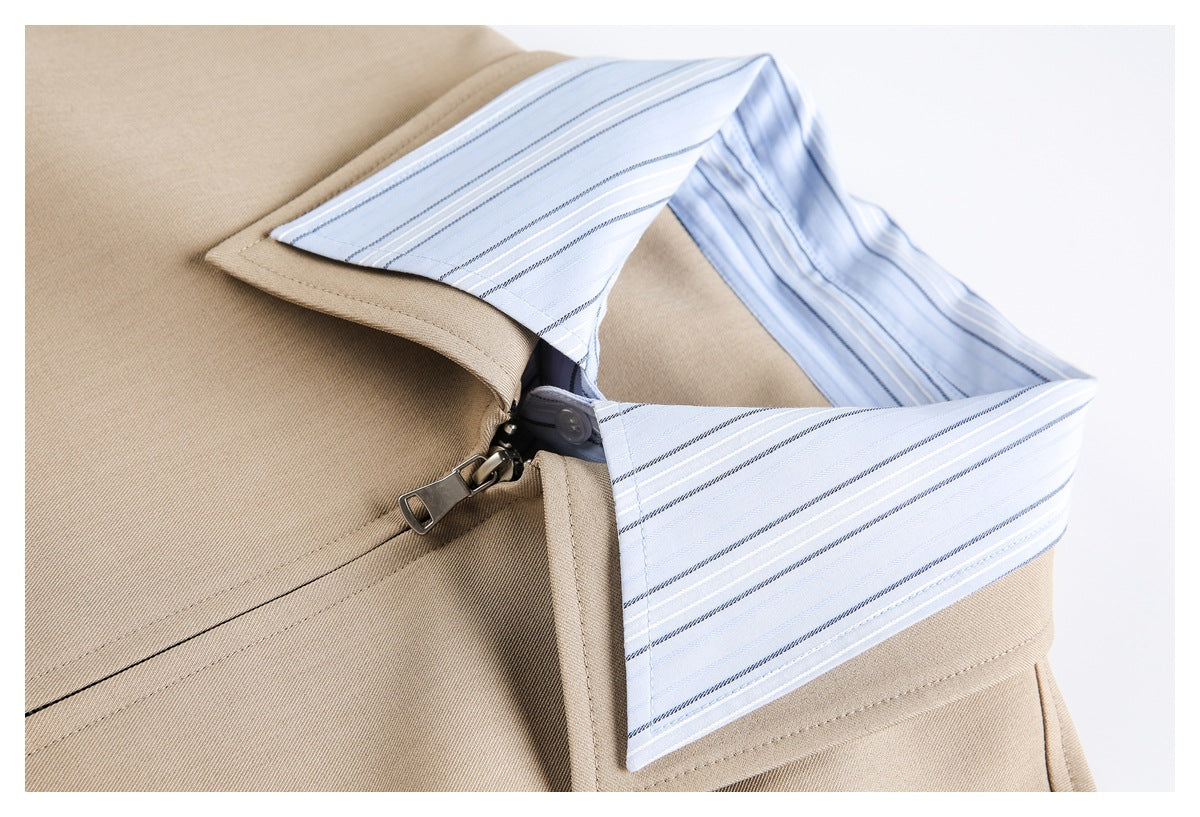 Close-up of a beige jacket collar and zipper layered over a light blue striped shirt collar.