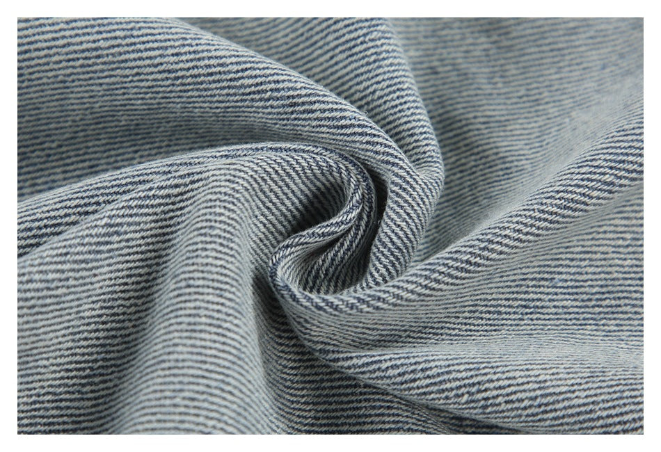 Close-up of blue-and-white diagonal denim twill gathered into soft folds.