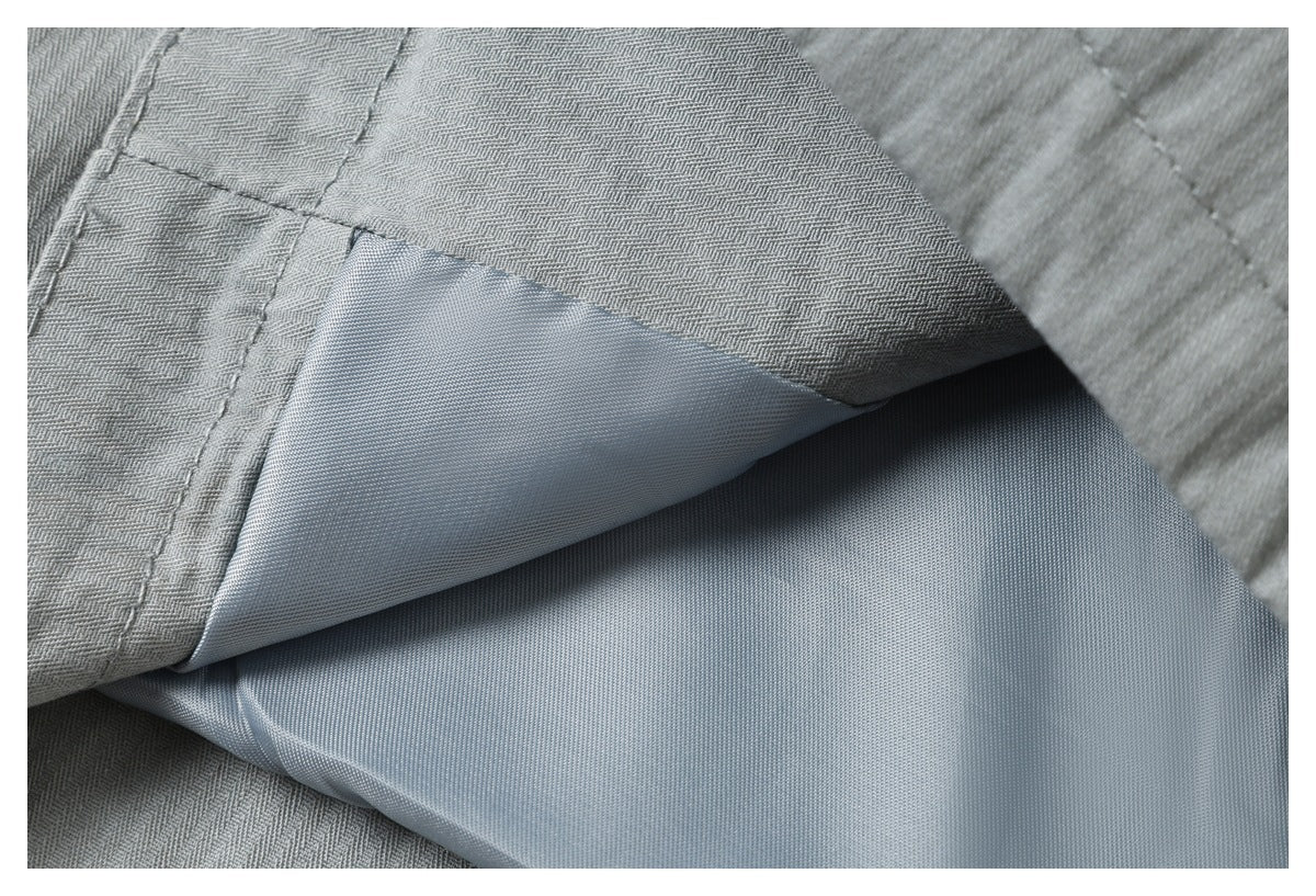 Close-up of light gray garment layers, showing the inner panel and stitched seams.