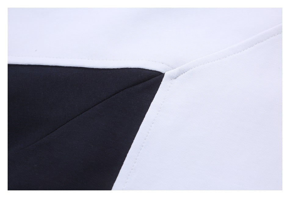 Close-up of the white shirt's seam joining a black fabric panel beneath the sleeve.