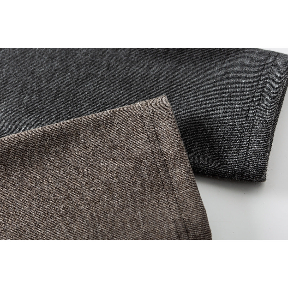 Close-up of charcoal and taupe heathered knit sleeves with stitched cuffs.