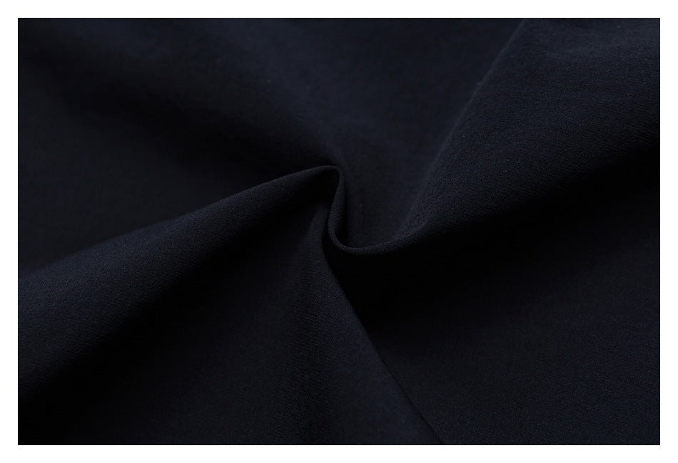 Extreme close-up of black fabric draped into a soft fold.