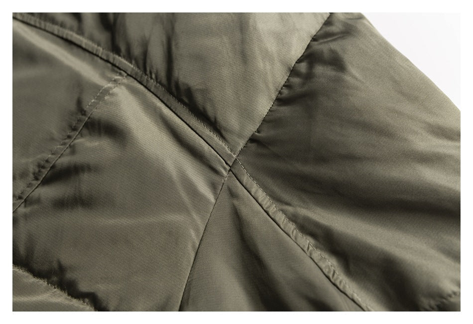 Close-up of an olive jacket showing intersecting stitched panels and seams.