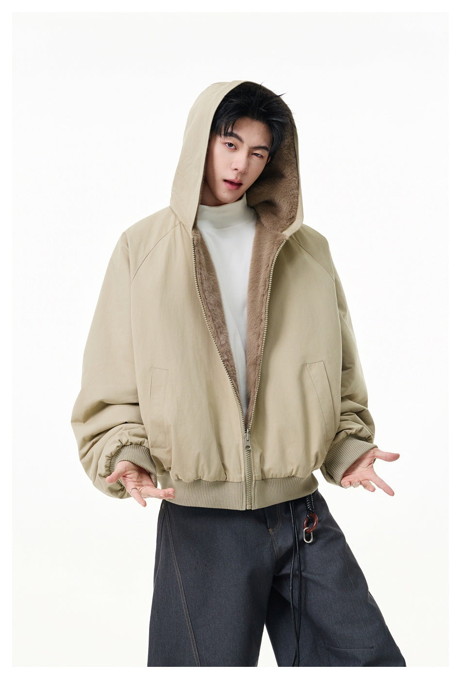 Model wears the beige outer side of a hooded jacket, open to show its plush taupe lining and front pockets.