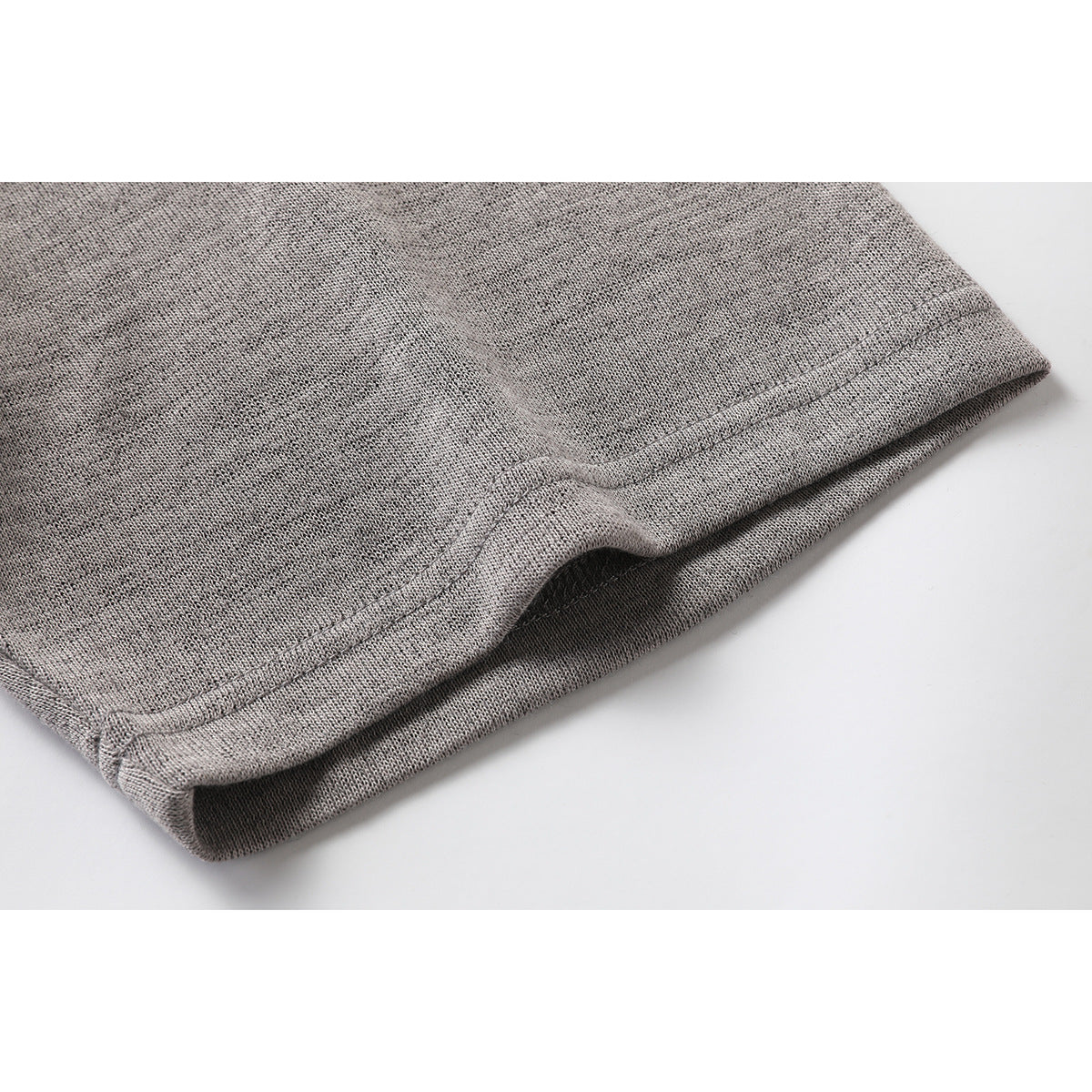 Close-up of the stitched hem on a heather gray T-shirt.