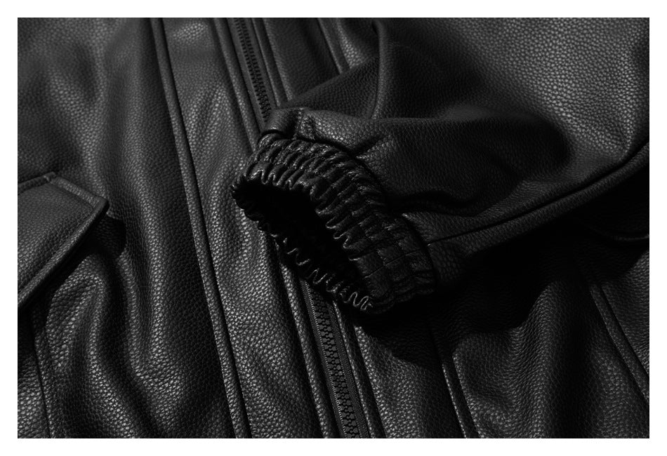 Close-up of a black pebbled jacket sleeve with a gathered cuff beside the front zipper.