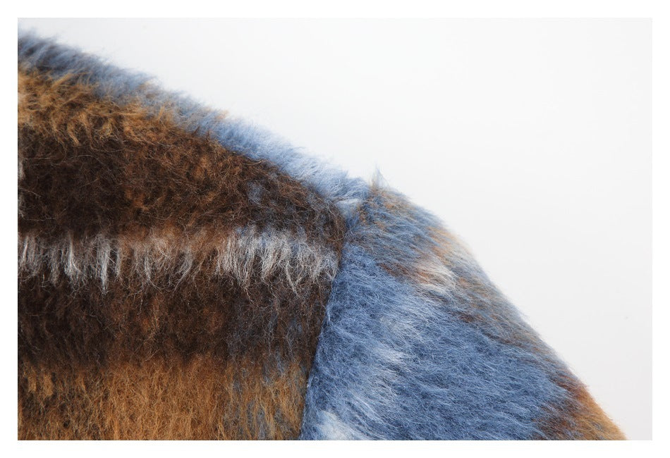 Close-up of the jacket's fuzzy brown, blue and cream plaid fabric at a seam.
