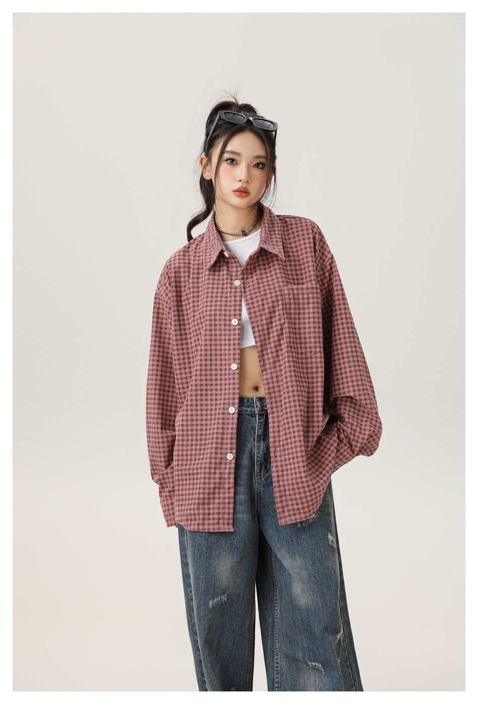 Model wearing a dusty-pink check shirt with a chest pocket and white buttons, paired with loose jeans.