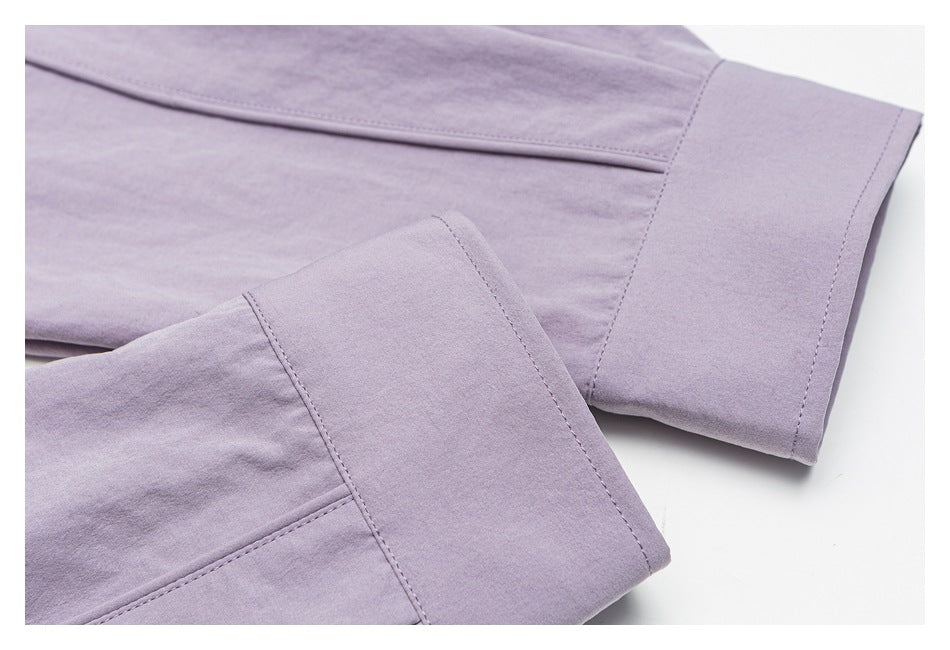Close-up of pale lavender shirt cuffs with wide bands and visible stitching.